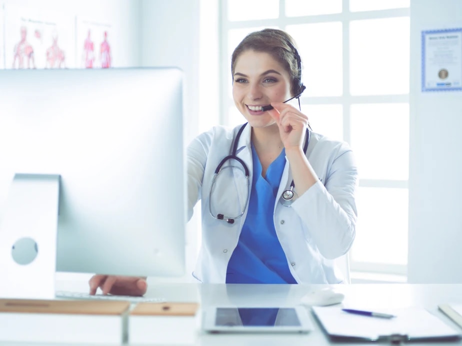 Behavioral health billing specialist on a headset reviewing a practice's revenue cycle