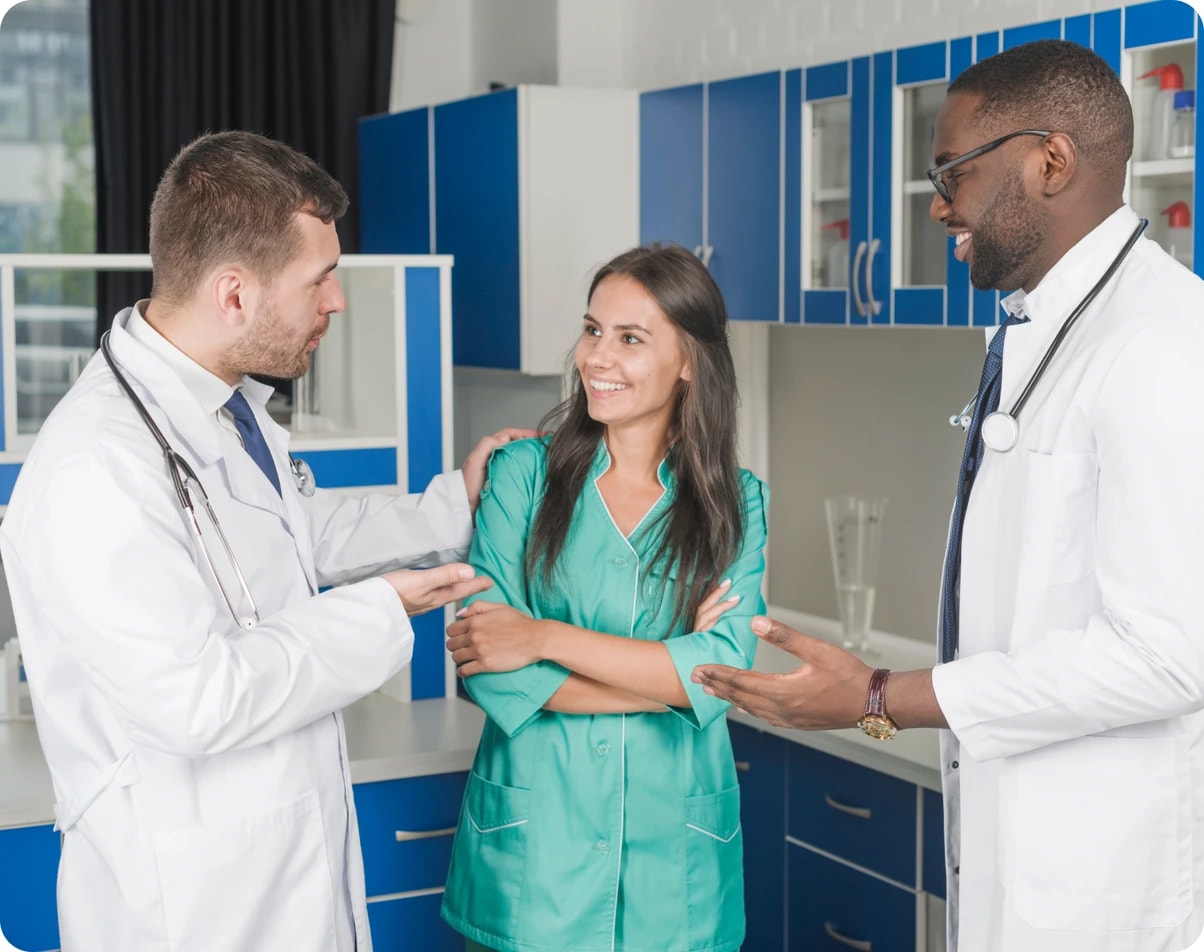 Two clinicians and a colleague talking in a practice corridor
