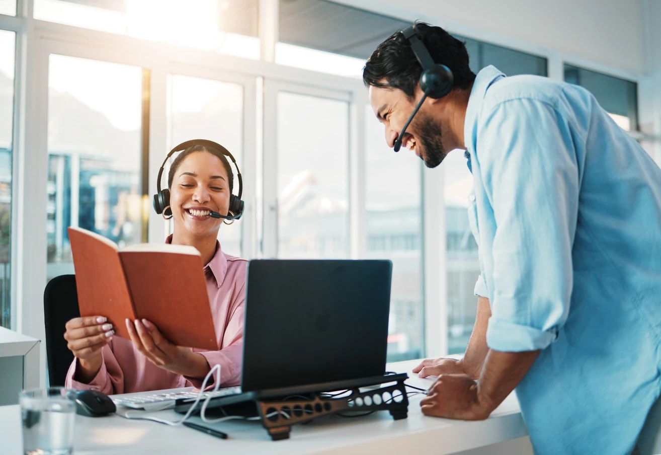 Two DastifyBH billing specialists reviewing a claim together at a shared desk