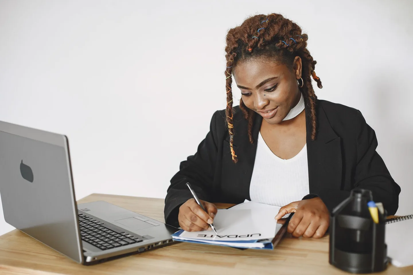 A professional reviewing paperwork beside a laptop.